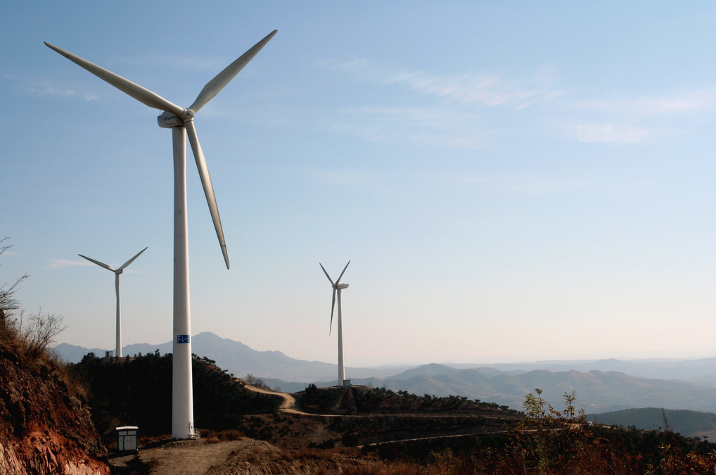 Photo of three windmills with low mountains in the background