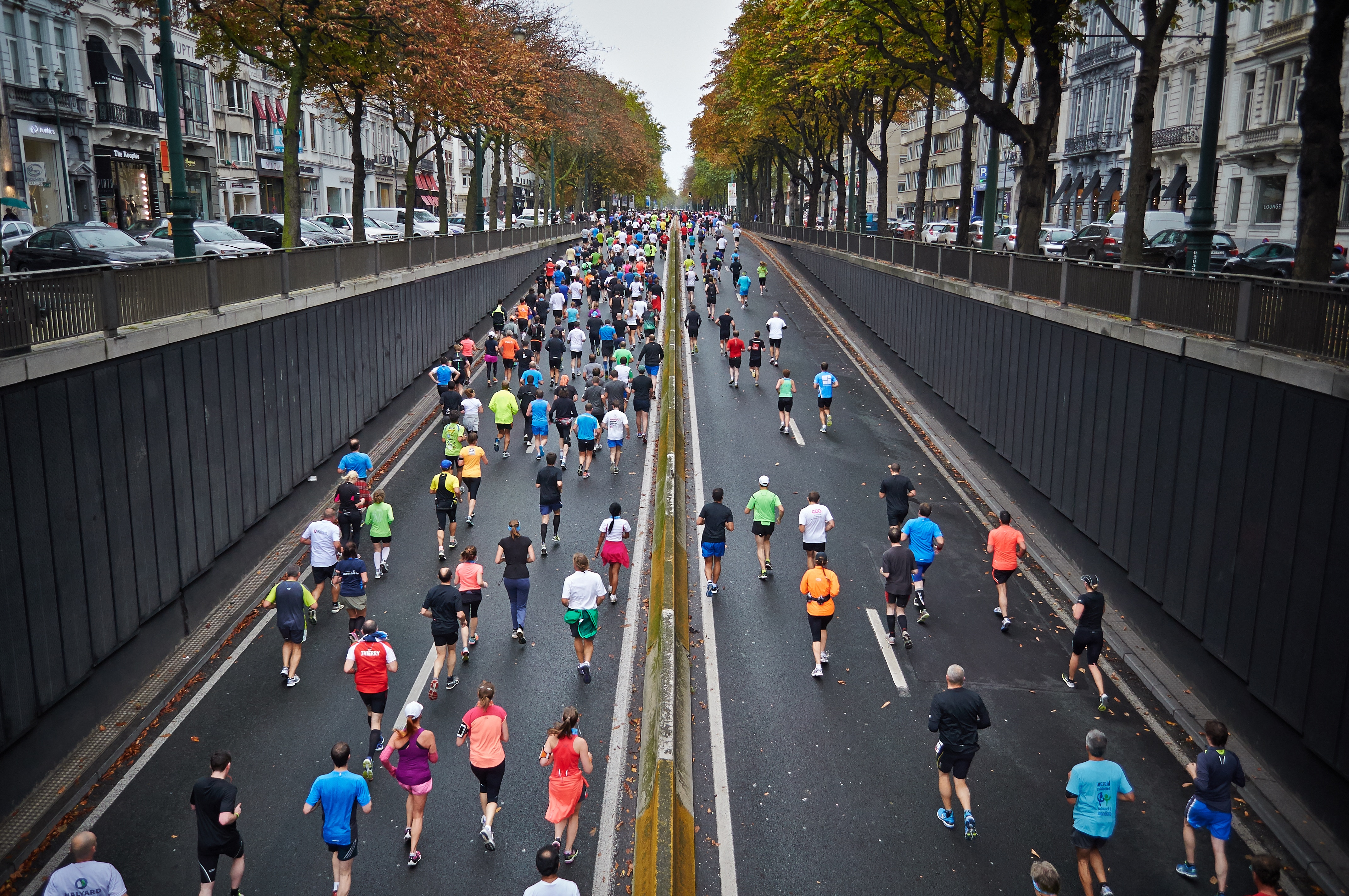 Photo of people running in a race through a city