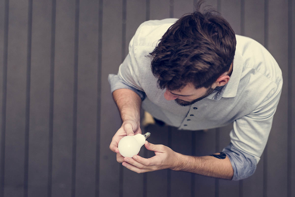 A photo of a man changing a light bulb