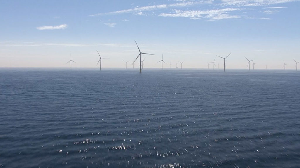 An image of wind turbines in the ocean off the coast of Grimsby, England.