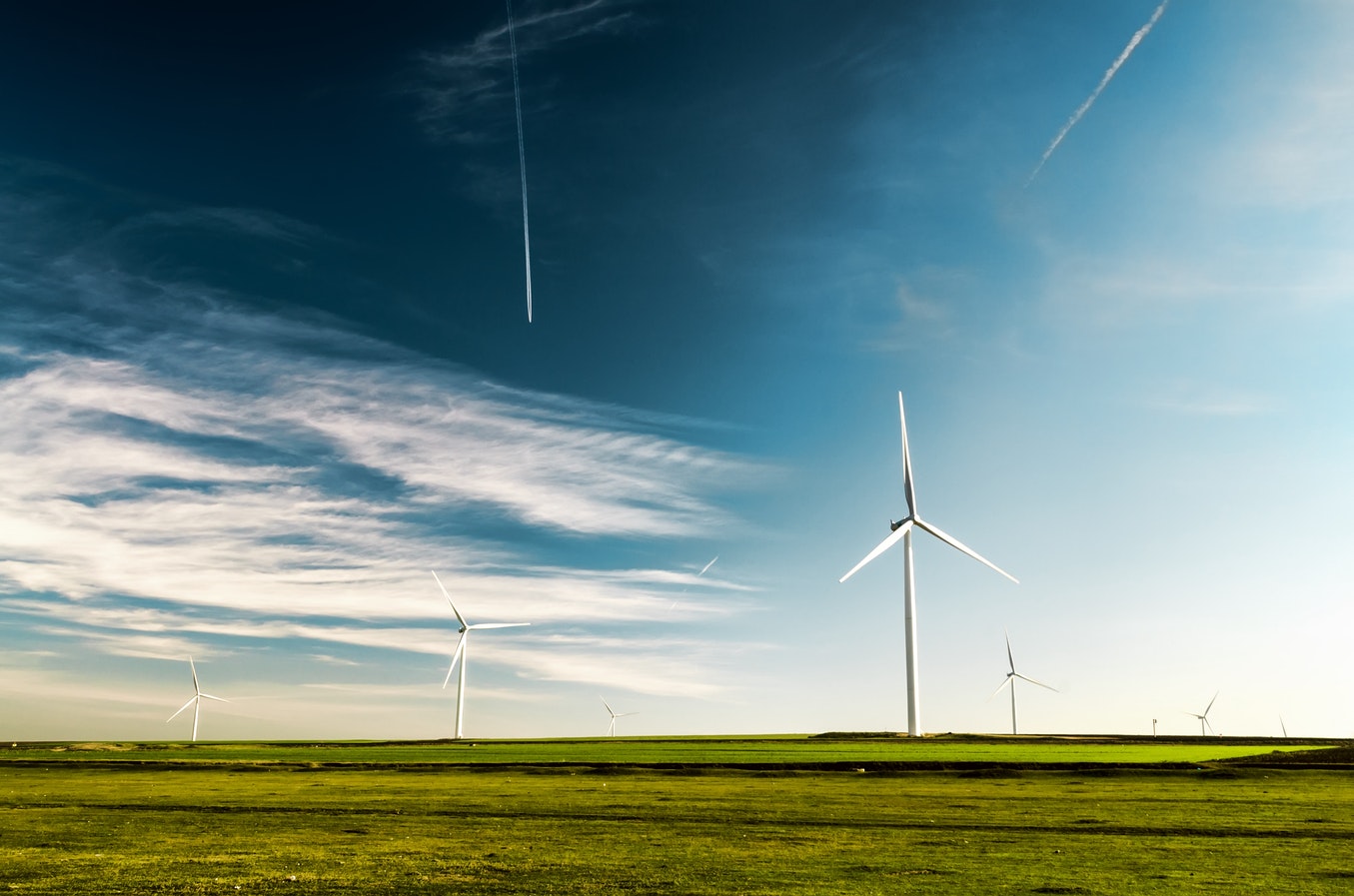 A photo of several wind turbines against a blue sky