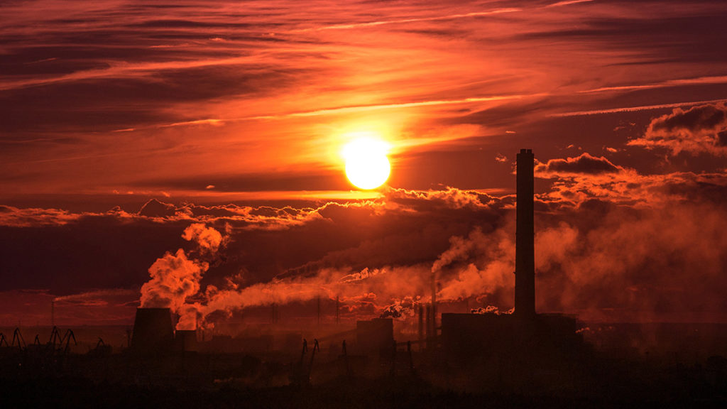 An image of the sunsetting over a coal power station.