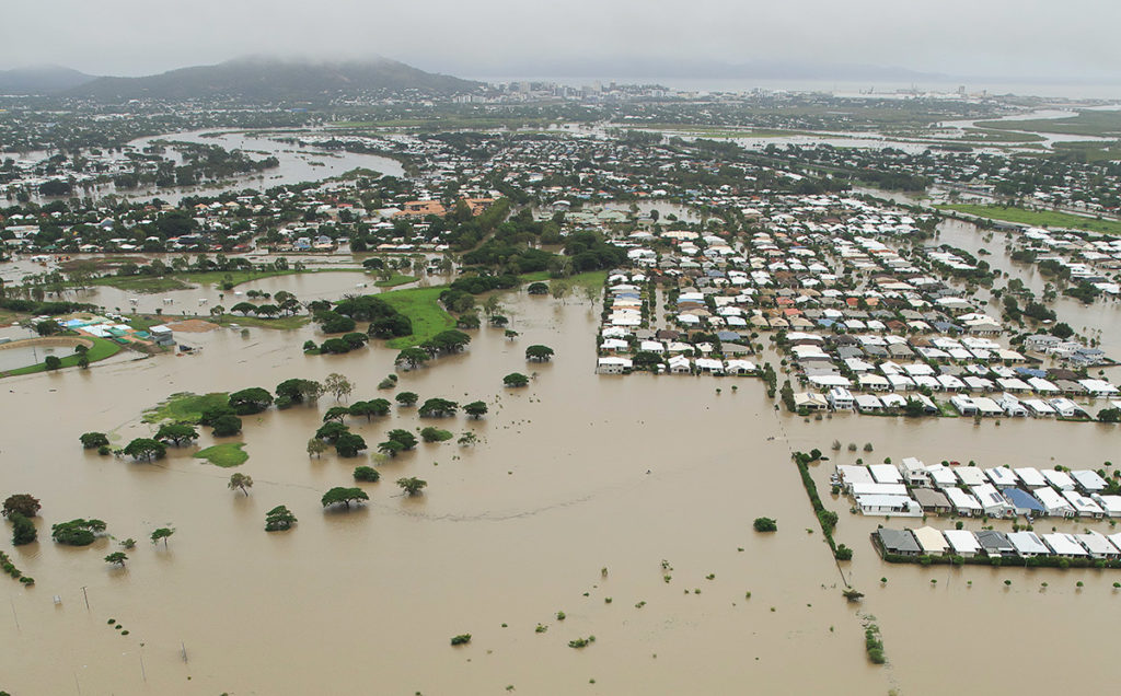 Stranded vehicles are seen from above as floodwater engulfs the intersection of Stuart Drive and the Bruce Highway in Townsville, Monday, February 4, 2019. Hundreds of people still waiting for help and evacuation centres are filling up fast, with unprecedented water releases from the city's swollen dam having sent torrents of water down the Ross River and into the city, swamping roads, yards and homes.