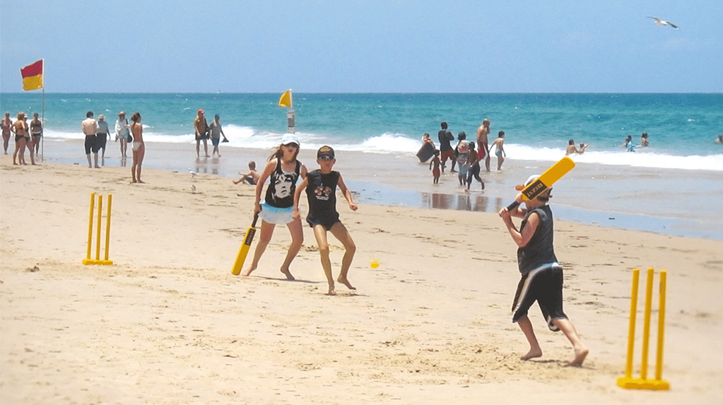 Photo of a children playing cricket on the beach