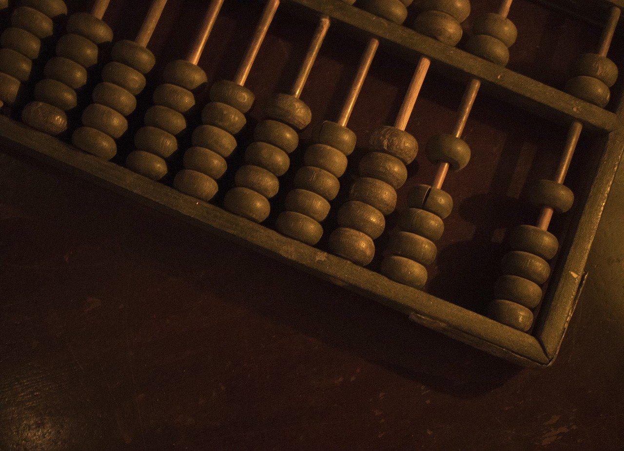 A stylised photo of an old, dark-beaded abacus