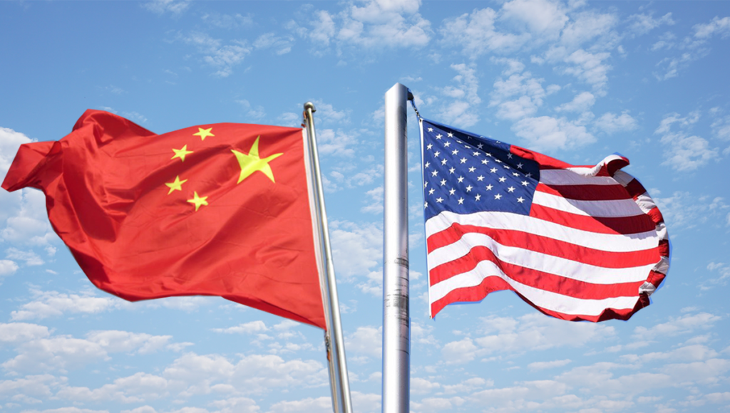 An image of China and USA flags in front of blue sky