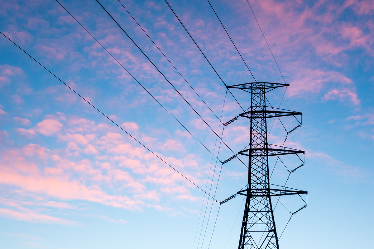 An image of power lines in front of a sunset.