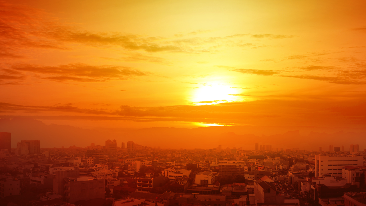 An image of a city with the sun setting in the background